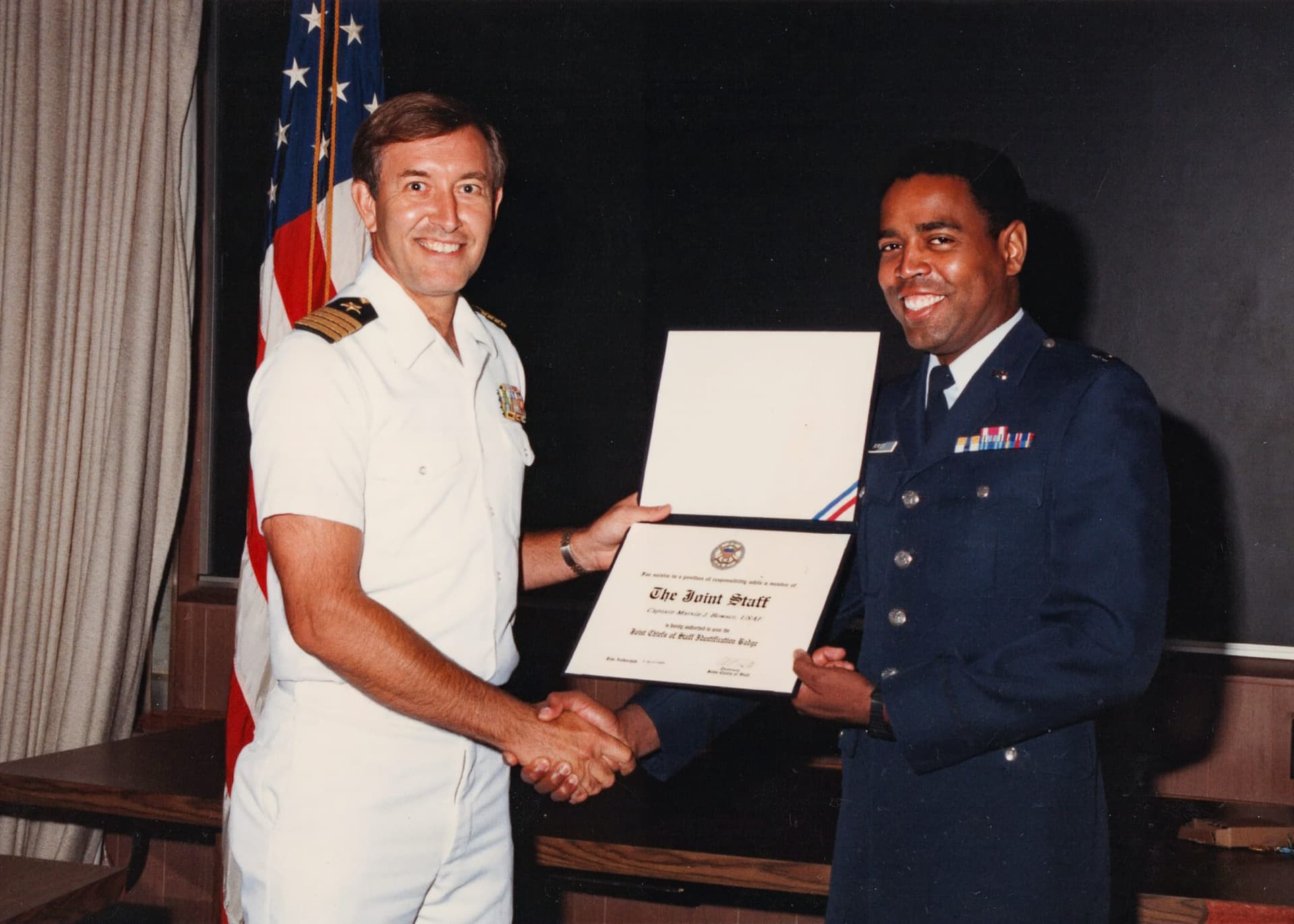 A man in uniform shaking another man's hand