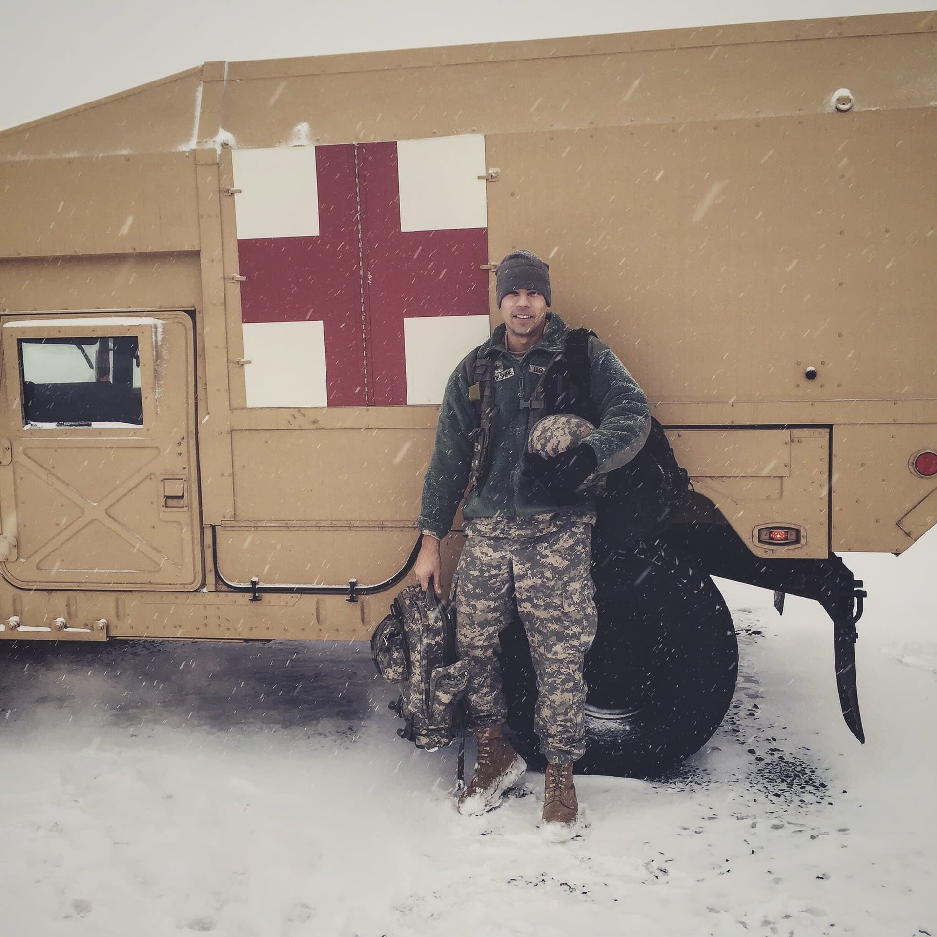 A man standing in front of a military vehicle