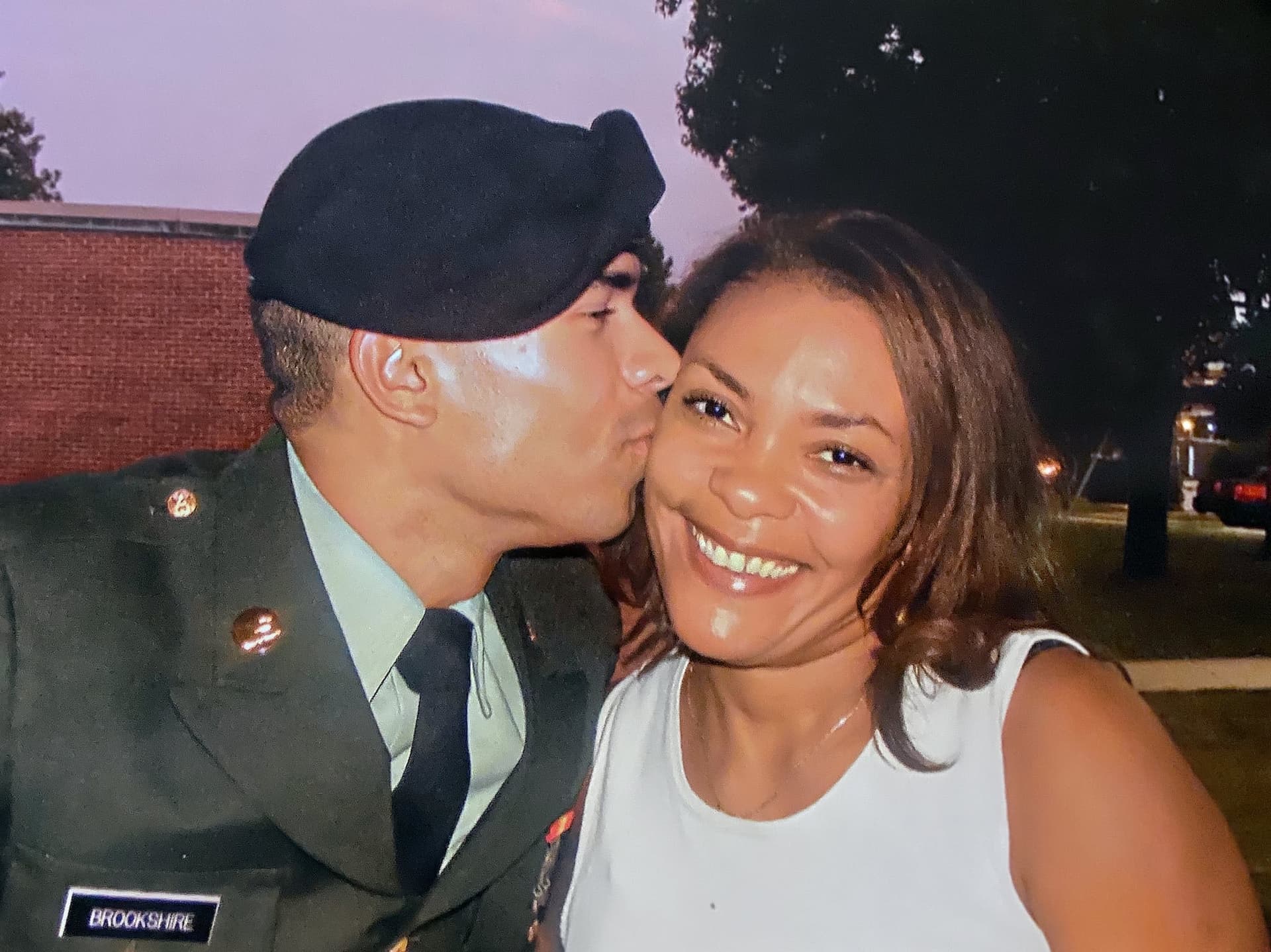 A man in a military uniform kissing a woman
