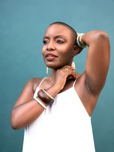 A woman in a white top is holding her hair up