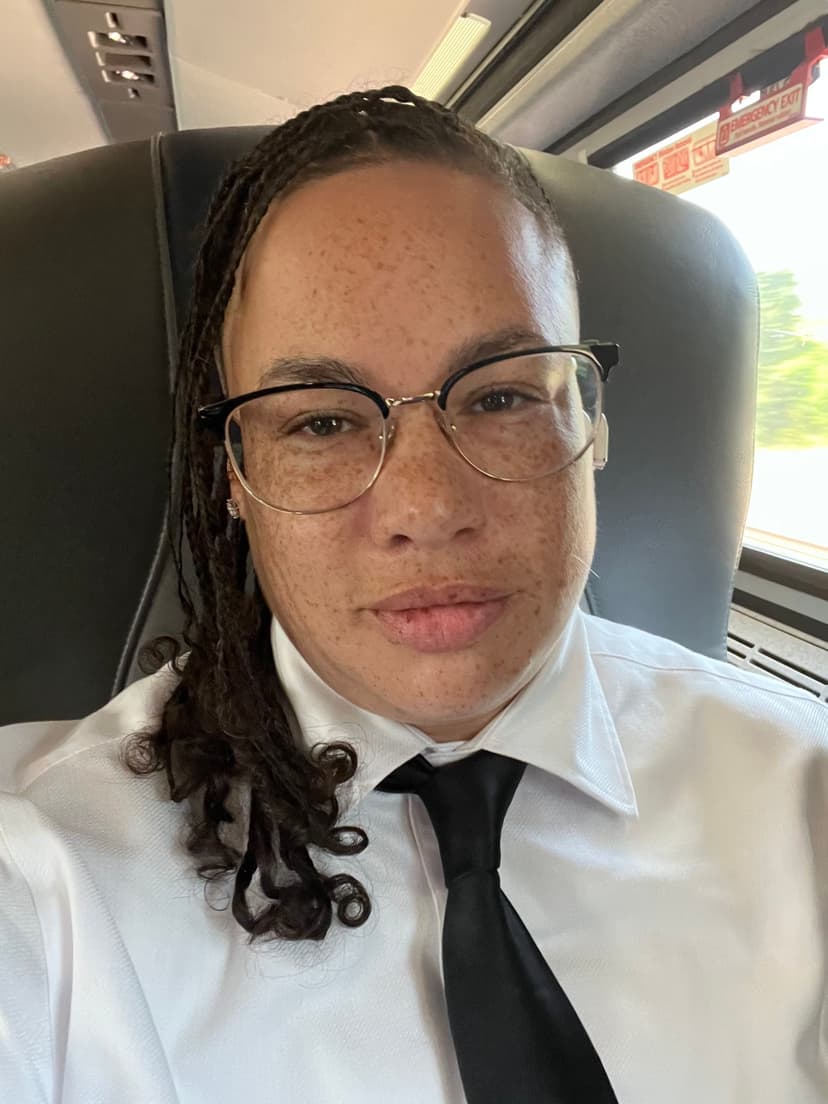A man with glasses and a tie on a bus