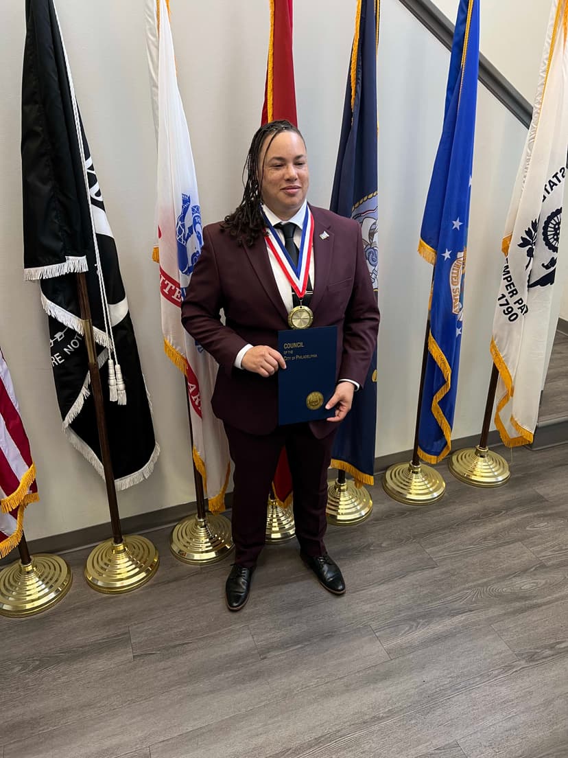 A man in a suit and tie holding a plaque