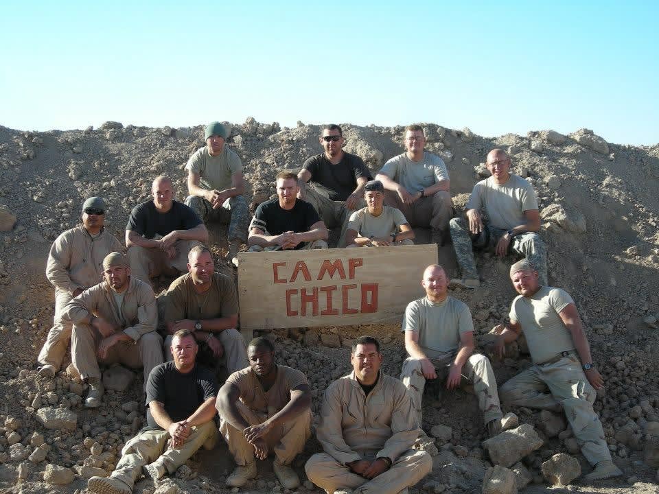 A group of men sitting on top of a pile of rocks