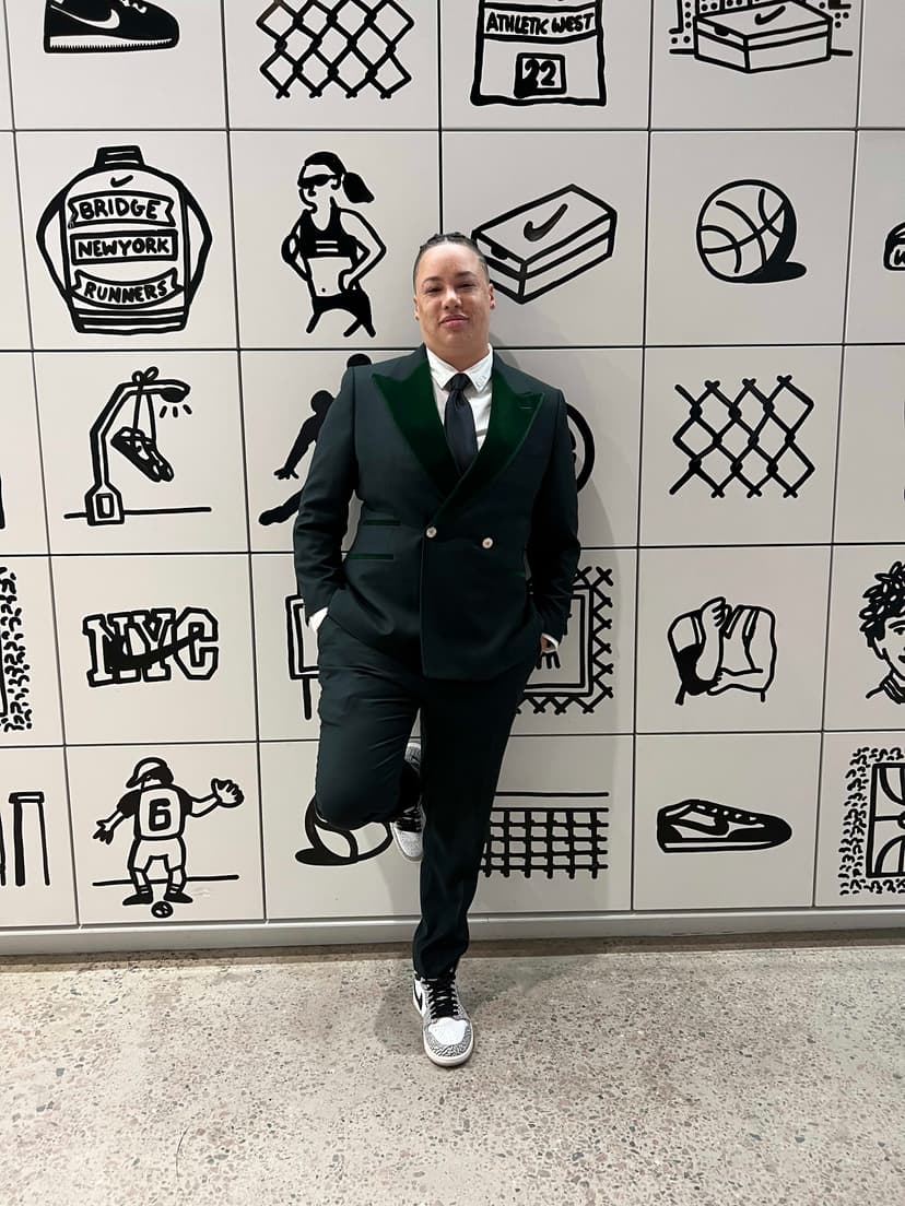 A man in a suit standing in front of a wall