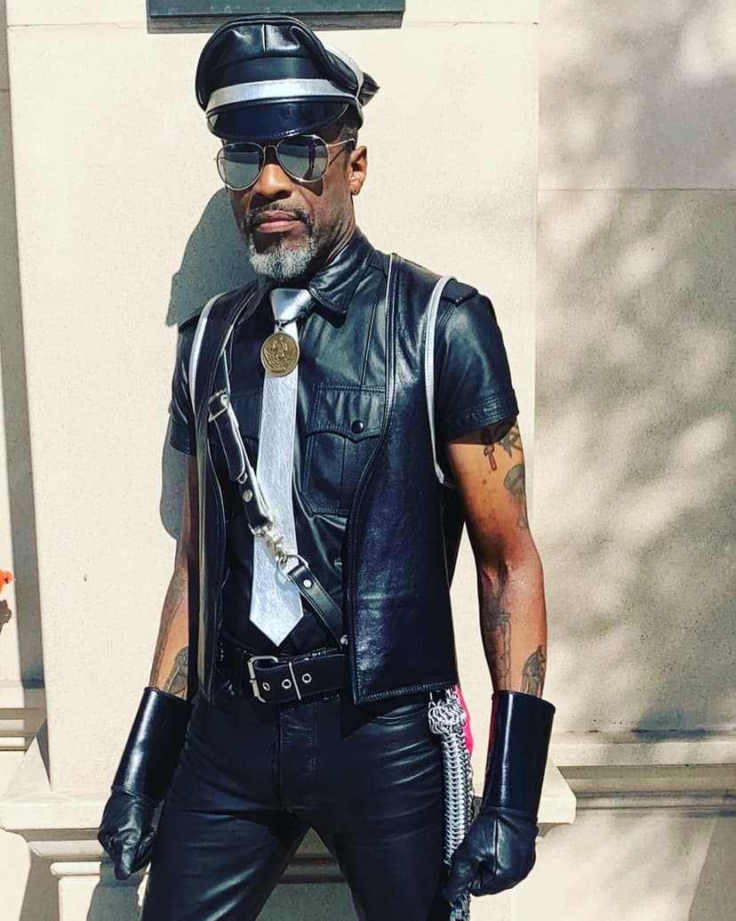 A man in a leather outfit and hat