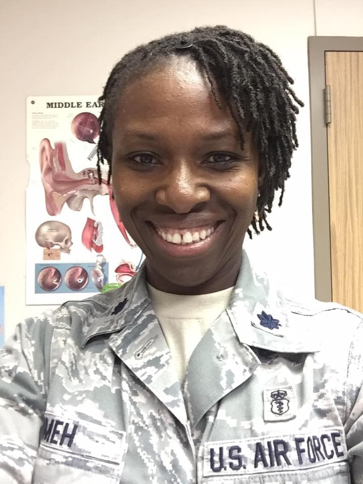 A woman in a military uniform smiling for the camera