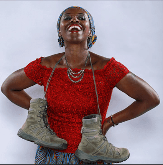 A woman in a red top holding a pair of shoes